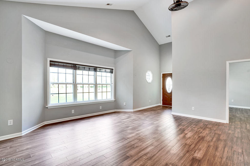 780 McKay Road Southeast Bolivia, NC 28422 - Photo 5 of 42 Vaulted ceilings in main entryway with upgraded ceiling fan, hardwood engineered floors and fresh paint.