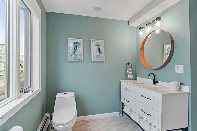 a bathroom with a toilet a sink and mirror