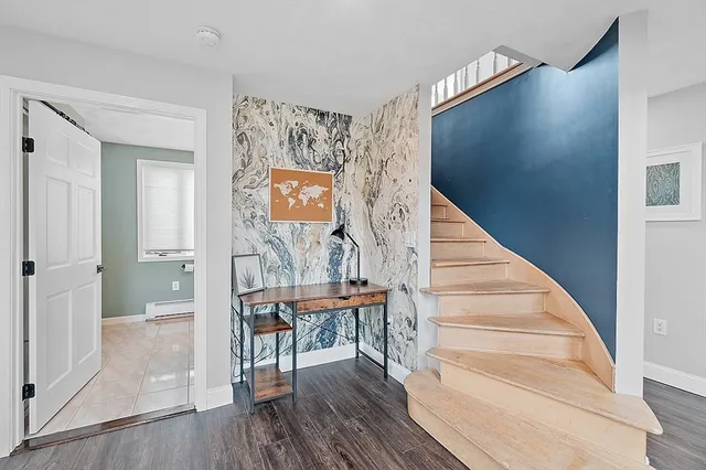 a view of a hallway with wooden floor and entryway