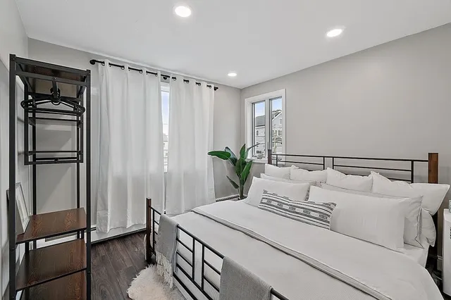 a bedroom with a bed and a refrigerator