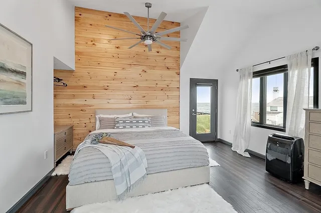 a bedroom with a bed and a flat tv screen on dresser
