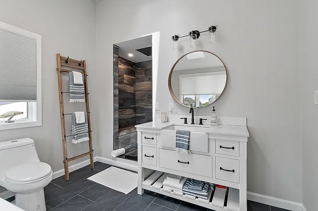 a bathroom with a sink a toilet and shower