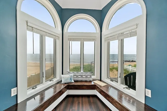 a view of hall with wooden floor and windows