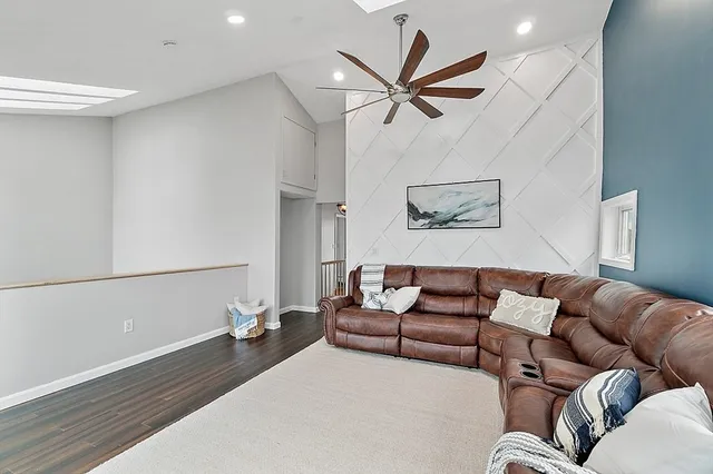 a living room with furniture and a ceiling fan