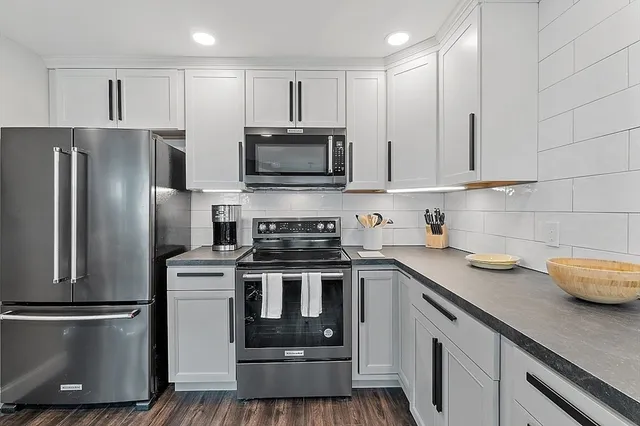 a kitchen with stainless steel appliances a stove a sink and a refrigerator
