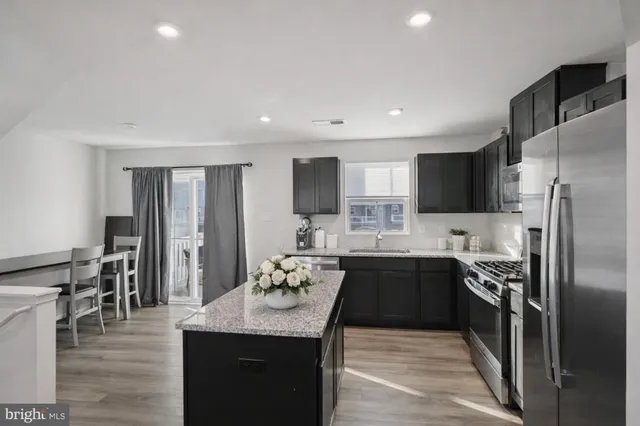 a kitchen with granite countertop kitchen island a sink appliances and cabinets