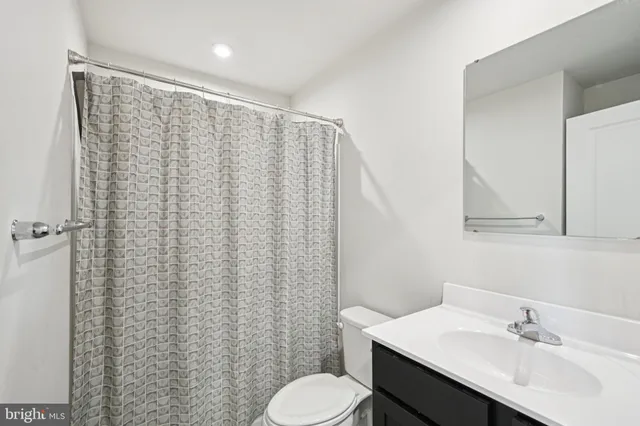 a bathroom with a sink toilet and mirror