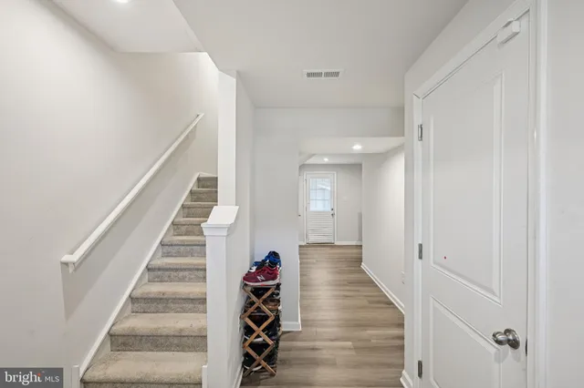 a view of a hallway with wooden floor and entryway