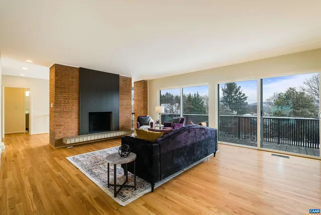 a dining room with wooden floor a chandelier a glass table and chairs
