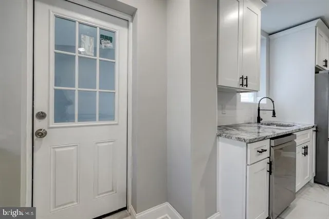 a kitchen with a granite countertop sink and cabinets