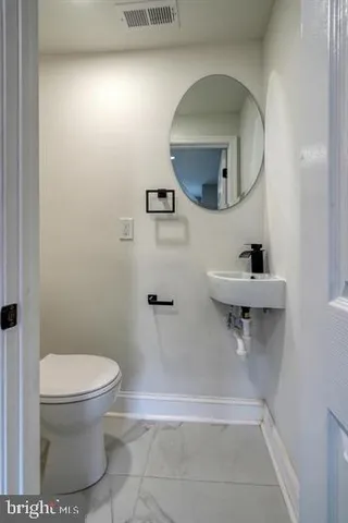 a bathroom with a toilet a sink and mirror