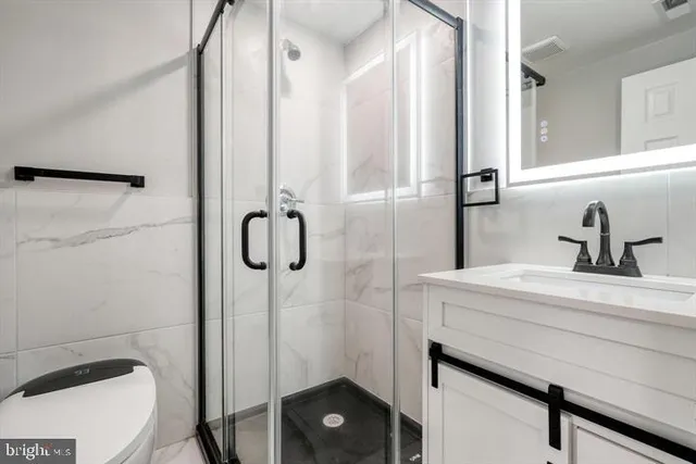 a bathroom with a sink a toilet and shower