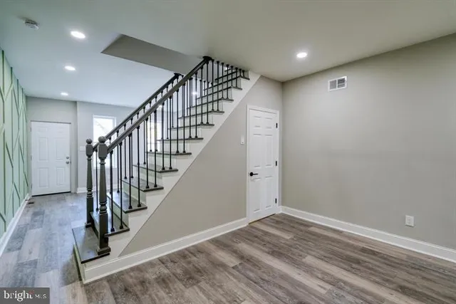 a view of room with stairs and wooden floor