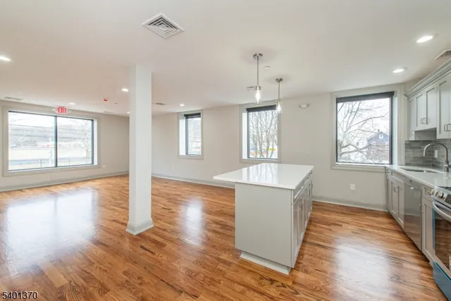 a view of a kitchen with wooden floor and a window