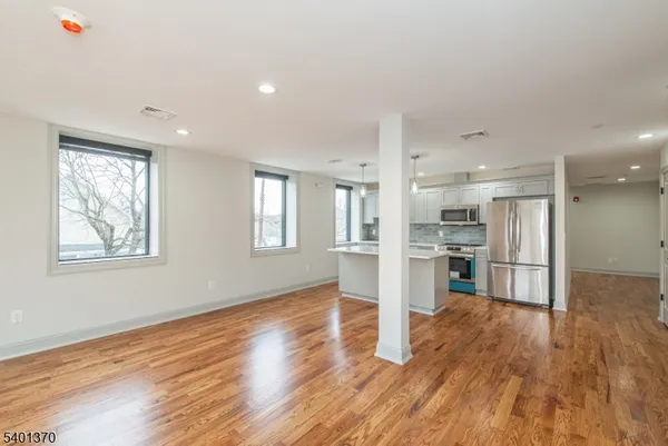a view of kitchen with wooden floor and electronic appliances