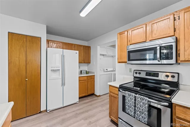 a kitchen with stainless steel appliances a stove a microwave and a hard wood floor