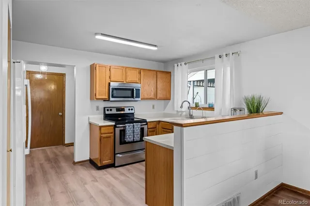 a kitchen with stainless steel appliances granite countertop a stove a sink and a refrigerator