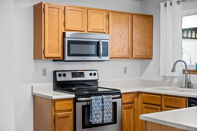 a kitchen with stainless steel appliances granite countertop a stove a sink and a microwave