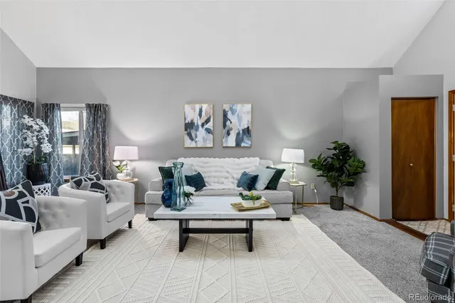 a living room with furniture and a potted plant