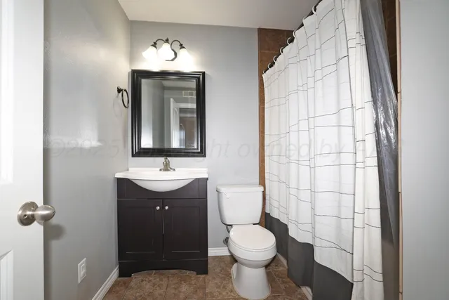 a bathroom with a sink and mirror with toilet