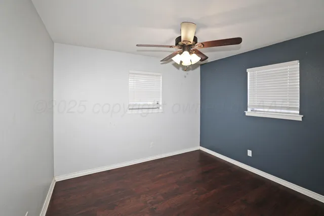 a view of a room with wooden floor and ceiling fan