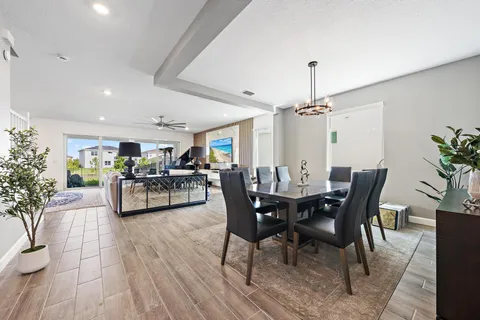 a view of a dining room and livingroom with furniture wooden floor a chandelier
