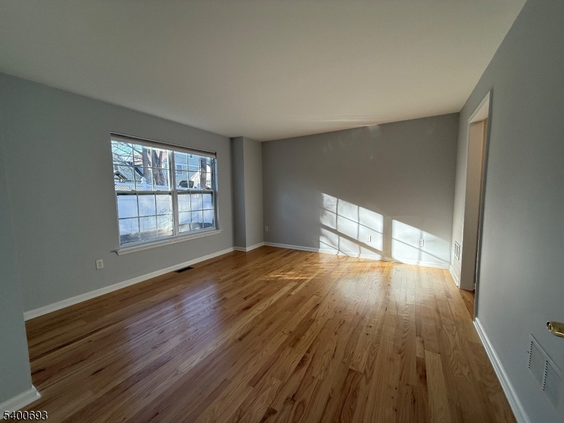 53 Division Avenue, Unit A5 New Providence, NJ 07901 - Photo 6 of 10 wooden floor in an empty room with a window