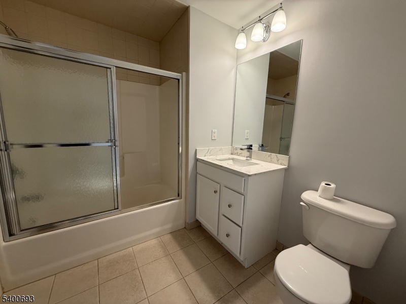 53 Division Avenue, Unit A5 New Providence, NJ 07901 - Photo 9 of 10 a bathroom with a sink a toilet a mirror and shower