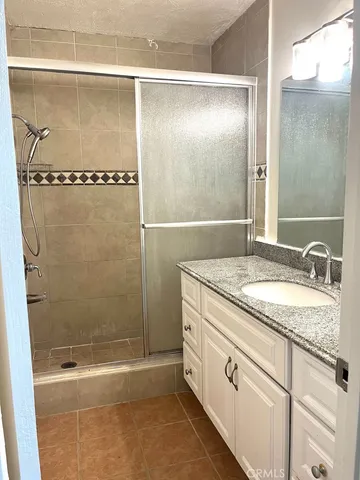 a bathroom with a granite countertop sink a mirror and a bathtub