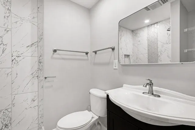 a bathroom with a sink a toilet and shower