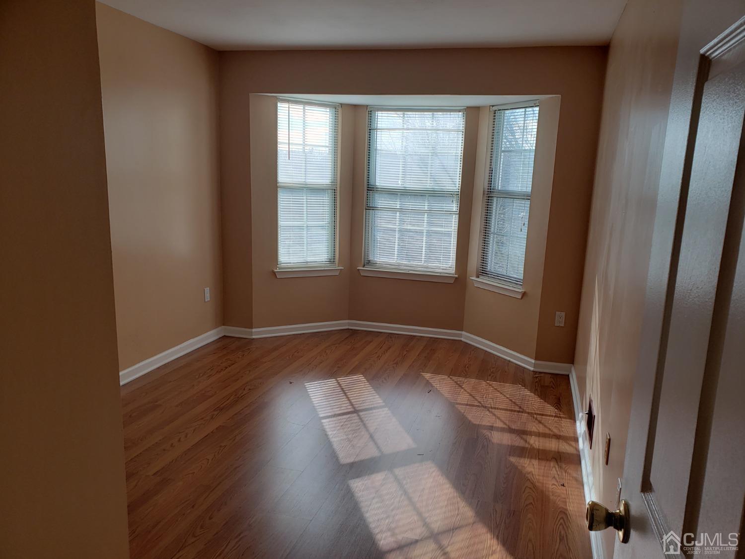 351 Wimbeldon Court North Brunswick, NJ 08902 - Photo 10 of 17 an empty room with wooden floor and windows