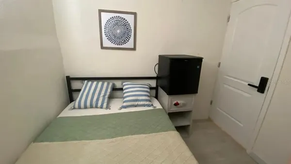 a view of a hallway with wooden floor and a bathroom