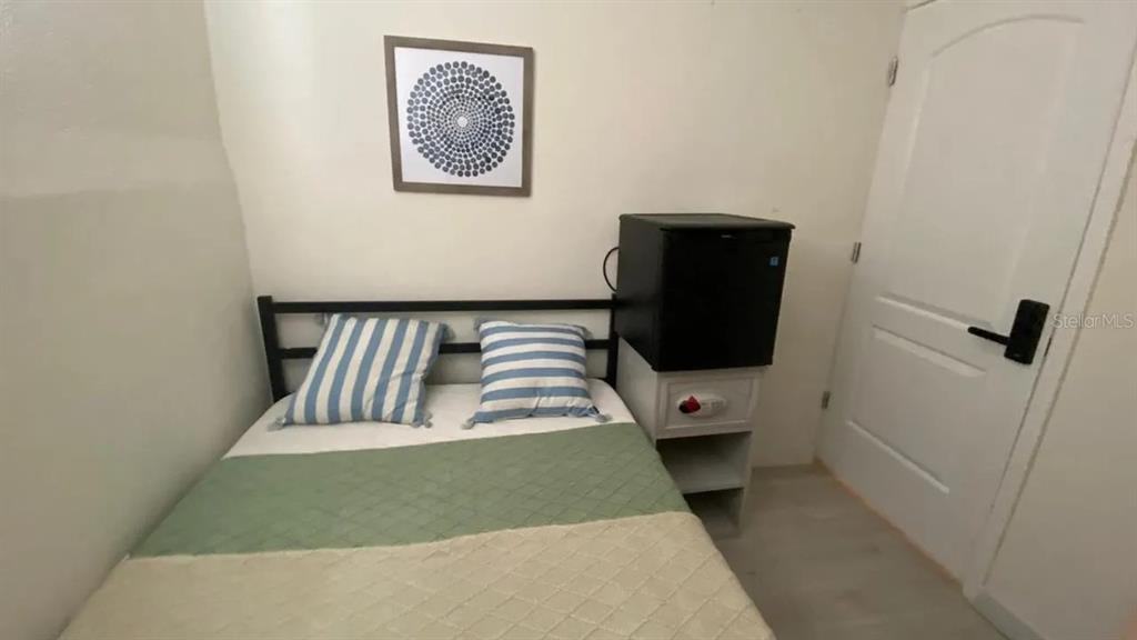 4427 Raleigh Street Orlando, FL 32811 - Photo 16 of 31 a bedroom with a bed and wall painting