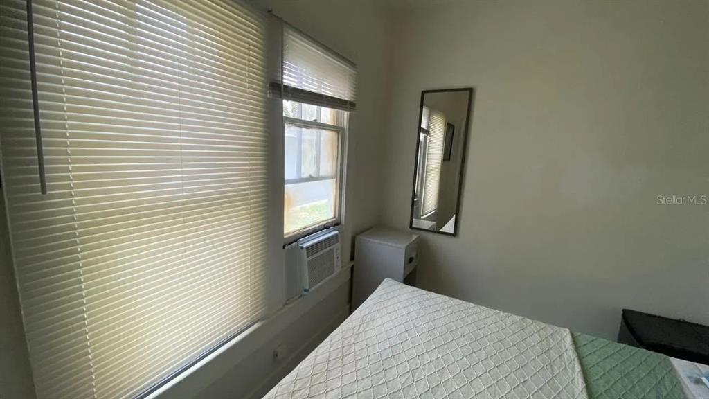 4427 Raleigh Street Orlando, FL 32811 - Photo 28 of 31 a bedroom with a bed and wooden floor