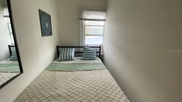 a bedroom with a bed and a mirror