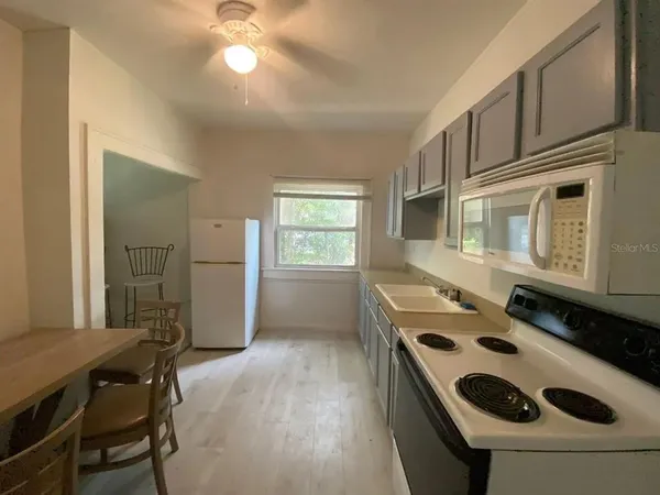 a kitchen with a sink a stove and cabinets