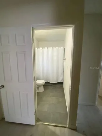 a view of a room that has a bed and a door in it
