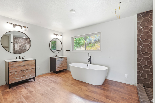 1410 Sumac Drive Logan, UT 84321 - Photo 14 of 28 Freestanding soaking tub with a floor-mounted matte black faucet, set against wood-finish flooring