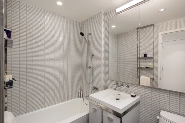 a bathroom with a sink mirror and a bathtub
