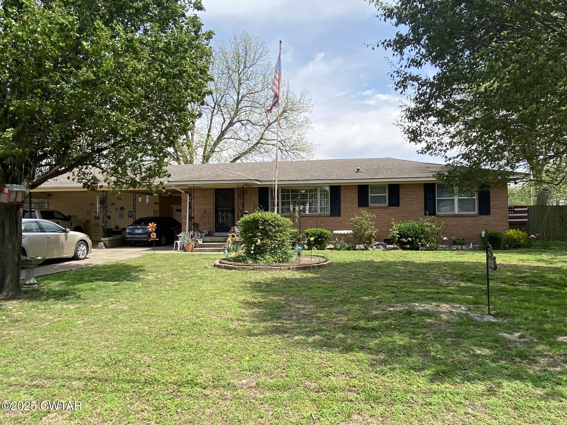 604 South Main Street Ridgely, TN 38080 - Photo 1 of 25 a front view of a house with a garden and trees