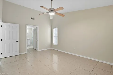 an empty room with a ceiling fan and a bathroom