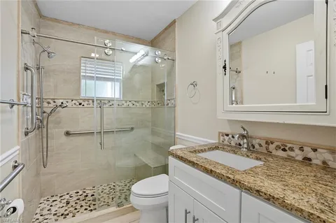 a bathroom with a granite countertop sink toilet and shower