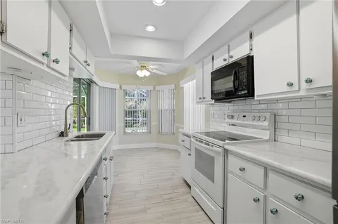 a kitchen with stainless steel appliances a stove microwave and sink