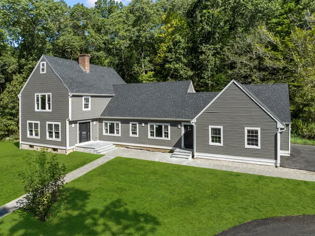 a front view of a house with a yard and trees
