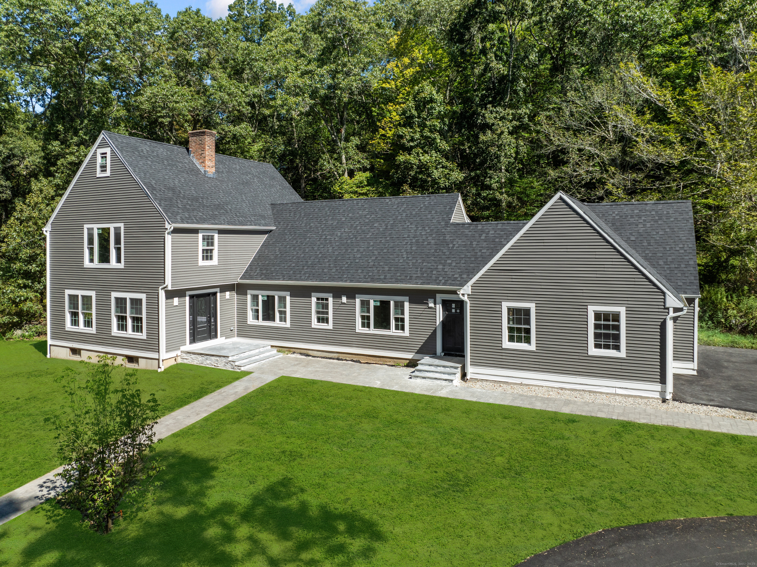 a front view of a house with a yard and trees