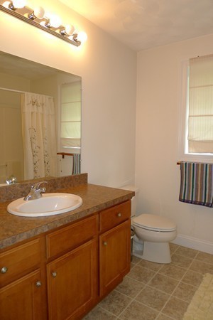 117 Tyler Road Townsend, MA 01469 - Photo 8 of 11 a bathroom with a granite countertop toilet a sink and a mirror