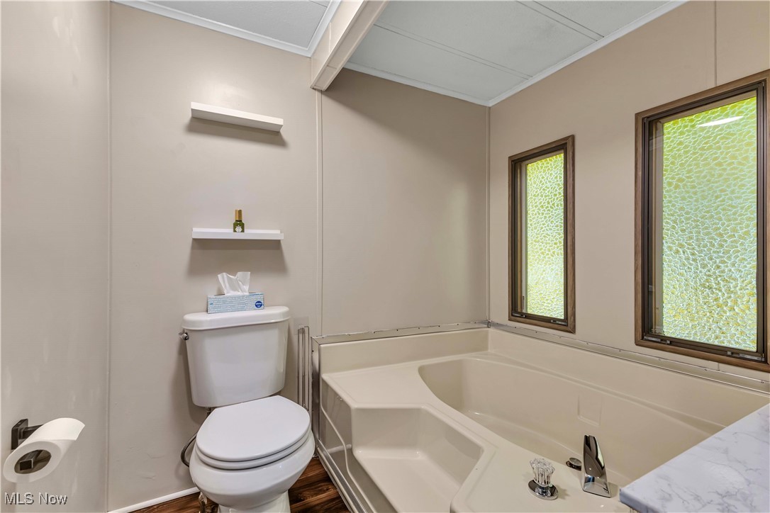 35157 Center Ridge Road, Unit 120 North Ridgeville, OH 44039 - Photo 18 of 25 Full bathroom featuring a bath, crown molding, and wood finished floors