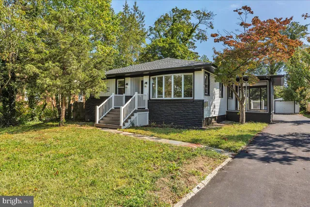 a front view of a house with a garden and yard