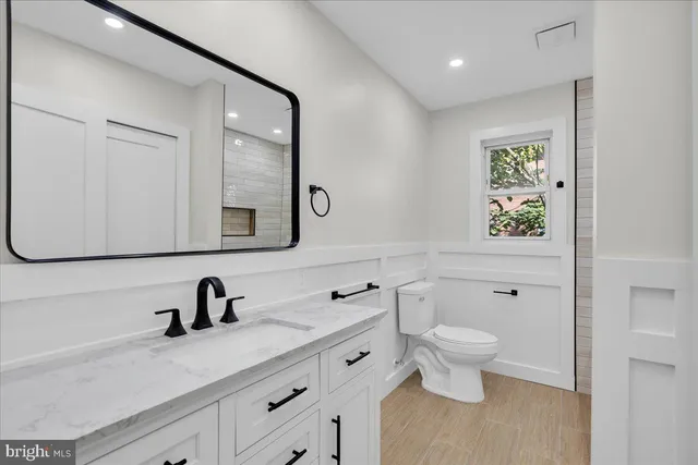 a bathroom with a toilet sink and mirror