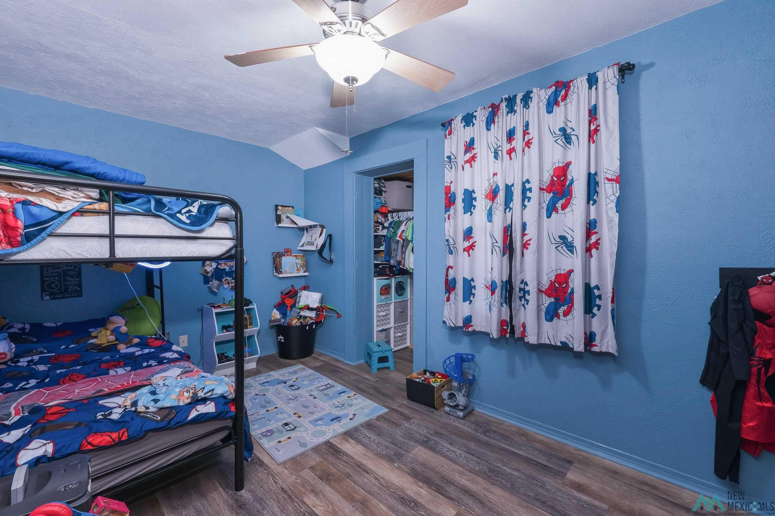 1432 South 5th Street Raton, NM 87740 - Photo 16 of 32 Bedroom with a ceiling fan, lofted ceiling, and dark wood-type flooring